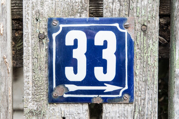 Weathered grunge square metal enameled plate of number of street address with number 33