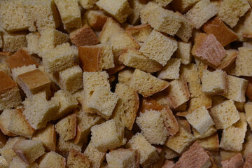 a lot of ruddy fried square croutons of white bread randomly scattered in a pile - close-up top view