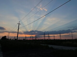 the sky in the clouds with the rays of the setting sun