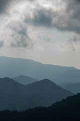 Fototapeta premium Mountain landscape with bright sun rays shining and cloudy sky in the morning.