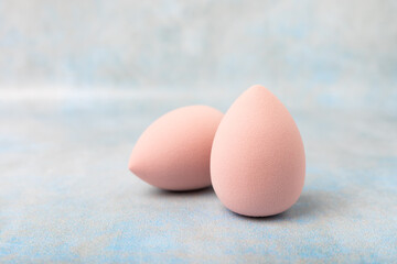 Beauty blender. Cosmetic sponge on a blue marble background. MOCAP. Sponge for applying foundation and concealer. Beauty concept. Space for text. Space for copy space.