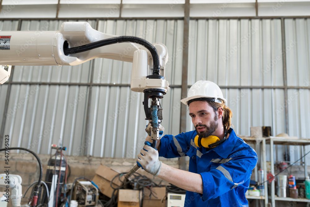 Leinwandbilder male engineers worker working with adept robotic arm in workshop. male engineer maintenance automati