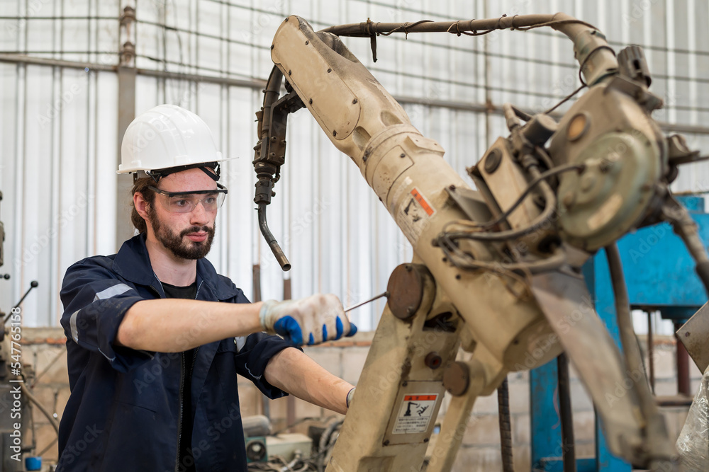Poster Male engineers worker working with adept robotic arm in workshop. Male engineer maintenance automatic robotic arm machines in factory. Industry robot manufacturing technology