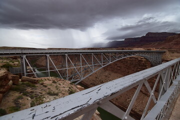 Historic Navajo bridge over Colorado river in Arizona with thunder storms clouds and rain coming in