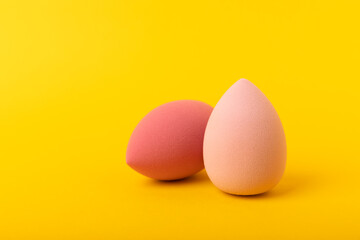 Beauty blender. Cosmetic sponge on a yellow background. MOCAP. Sponge for applying foundation and concealer. Beauty concept. Space for text. Space for copy space.