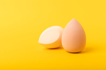 Beauty blender. Cosmetic sponge on a yellow background. MOCAP. Sponge for applying foundation and concealer. Beauty concept. Space for text. Space for copy space.