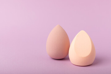 Beauty blender. Cosmetic sponge on a lilac background. MOCAP. Sponge for applying foundation and concealer. Beauty concept. Space for text. Space for copy space.