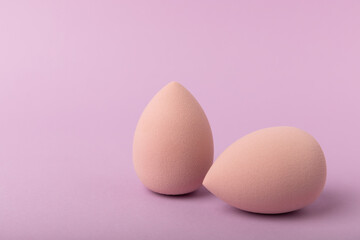 Beauty blender. Cosmetic sponge on a lilac background. MOCAP. Sponge for applying foundation and concealer. Beauty concept. Space for text. Space for copy space.