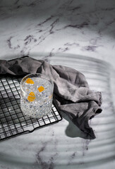 a glass of gin and tonic on a gray concrete background, a gray napkin lies nearby