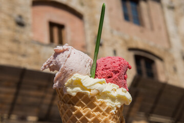 Three scoops of gelato in a cone in San Gimignano, Italy.