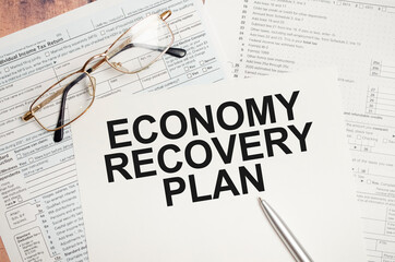 ECONOMY RECOVERY PLAN words on paper with tax forms