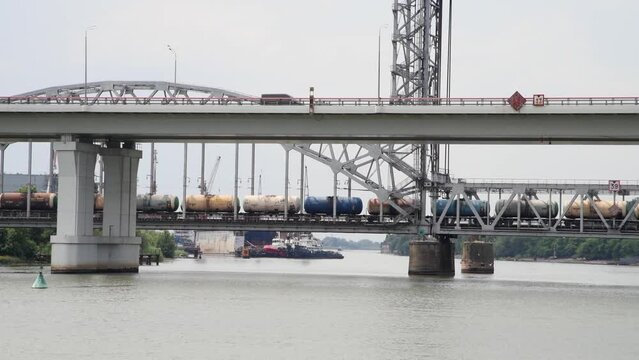 Side of freight trane with tank wagons crossing Don river on bascule bridge. Real time video. Selective focus. Railway transportation theme.