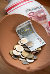 Clay broken money saving box with euro coins and banknotes. Home financial  investment