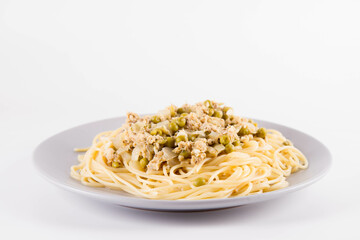 Spaghetti with smoked mackerel and green peas cream sauce on a white background
