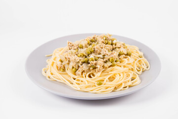 Spaghetti with smoked mackerel and green peas cream sauce on a white background