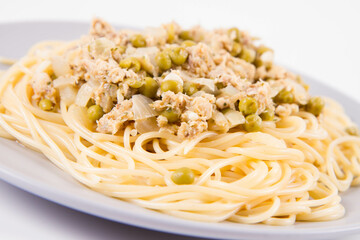 Spaghetti with smoked mackerel and green peas cream sauce on a white background