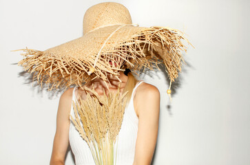 Woman in straw hat holding dry ears	