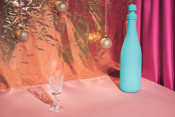 Glass of champagne and bottle of wine on the table. Christmas celebration. pastel color