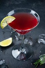 Maritini cocktail with juice in a glass with lime.