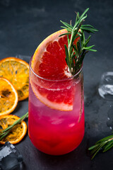 Fresh Ruby Red Grapefruit Paloma cocktail with tequila, syrup, grapefruit, rosemary and ice.