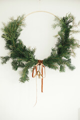 Merry Christmas and Happy Holidays! Modern Christmas wreath with velvet ribbon and golden bells...