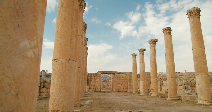Symmetric columns placed in rows in Cardo maximus in Jerash, Jordan. Ancient pillars kept in Roman style situated in Middle East. Ionic style identical colonnade and architecture. 4k panning shot