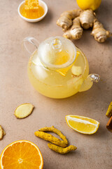 Close up of orange ginger tea in glass teapot  food roots turmeric fruits