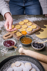 Weihnachten Plätzchen backen, Weihnachtsbäckerei, frisch gebackene Plätzchen mit verschiedenen Marmeladen füllen, Spitzbuben Plätzchen