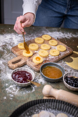 Weihnachten Plätzchen backen, Weihnachtsbäckerei, frisch gebackene Plätzchen mit verschiedenen Marmeladen füllen, Spitzbuben Plätzchen