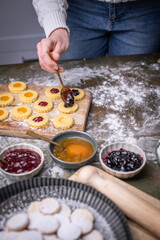 Weihnachten Plätzchen backen, Weihnachtsbäckerei, frisch gebackene Plätzchen mit verschiedenen Marmeladen füllen, Spitzbuben Plätzchen