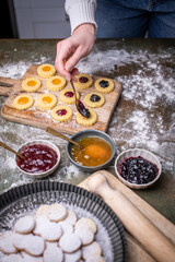Weihnachten Plätzchen backen, Weihnachtsbäckerei, frisch gebackene Plätzchen mit verschiedenen Marmeladen füllen, Spitzbuben Plätzchen