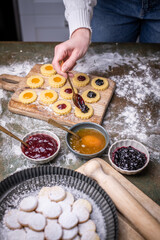 Weihnachten Plätzchen backen, Weihnachtsbäckerei, frisch gebackene Plätzchen mit verschiedenen Marmeladen füllen, Spitzbuben Plätzchen