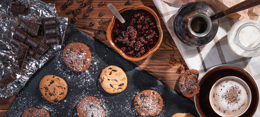 Cookies with chocolate and coffee on a wooden table, banner, flat lay, top view