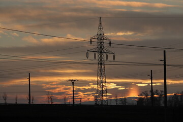 Fototapeta na wymiar High voltage pole. Electrical distribution network. Infrastructure. High voltage pylons. Sunset.