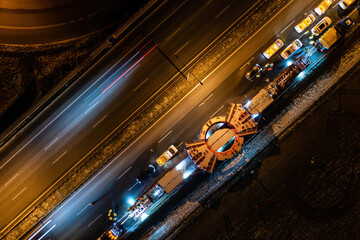 Convoy transporting heavy equipment, aerial night landscape of TBM machine