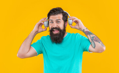 Fototapeta na wymiar listening to music. modern device of glad guy. hipster guy listening music in earphones