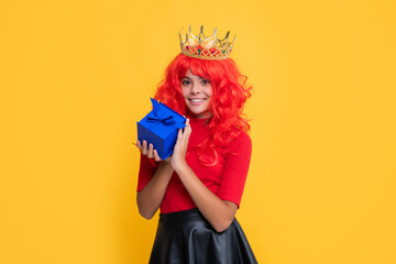 child smile in princess crown with present box on yellow background
