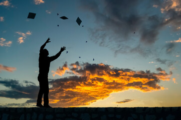 A lonely man`s silhouette with his hands up at sunset