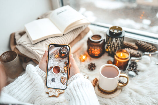 The girl takes a photo of the Christmas decor, the phone is in her hands