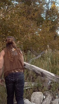 Man with long curly hair aiming and throwing a knife 