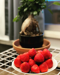 Fresh strawberries on a plate on a home background