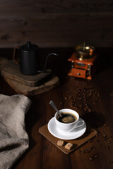 Cup of coffee and sugar with beans at wood table. Coffee still life on table