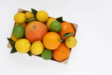 Mix of citrus fruits. Oranges, grapefruit, lemons and limes with leaves in wooden box on white background. Top view. Photo from above. © ivoraobrazy