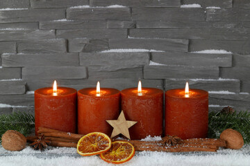 Fotoserie zur Adventszeit: Adventskerzen mit Zimtstangen und Orangenscheiben auf einer Baumscheibe dekoriert.