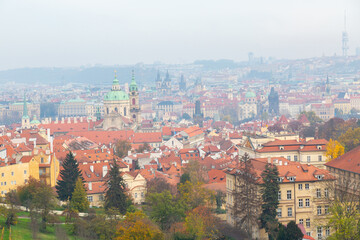 Fototapeta na wymiar Tourism in Europe. View on old streets of Prague in the morning, city center, Czech Republic, European travel. Typical old buildings with red tile roofs in Prague in foggy day. 
