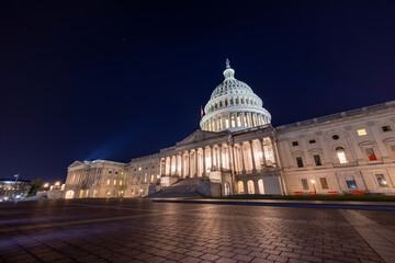 The east side of the United States Capitol Building in Washington, DC on a late autumn night. Spotlights illuminate the Capitol Dome and Statue of Freedom. No people are seen..