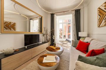Living room of a vacation rental apartment with fabric sofas and cushions and a large mirror on the wall