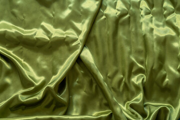 yellow-green satin fabrics lying on the ground with some water