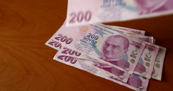 Turkish lira banknotes of two hundred lira close-up fall on the table and on top of each other. The concept of economic problems and the depreciation of the value of the Turkish lira