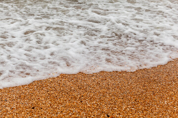 The seas are full on the sandy shore on a cloudy day. Rest on the sea. There is an empty space for text